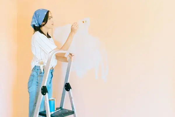 Interior painting in Tampa: painter on a stepladder rolling a wall